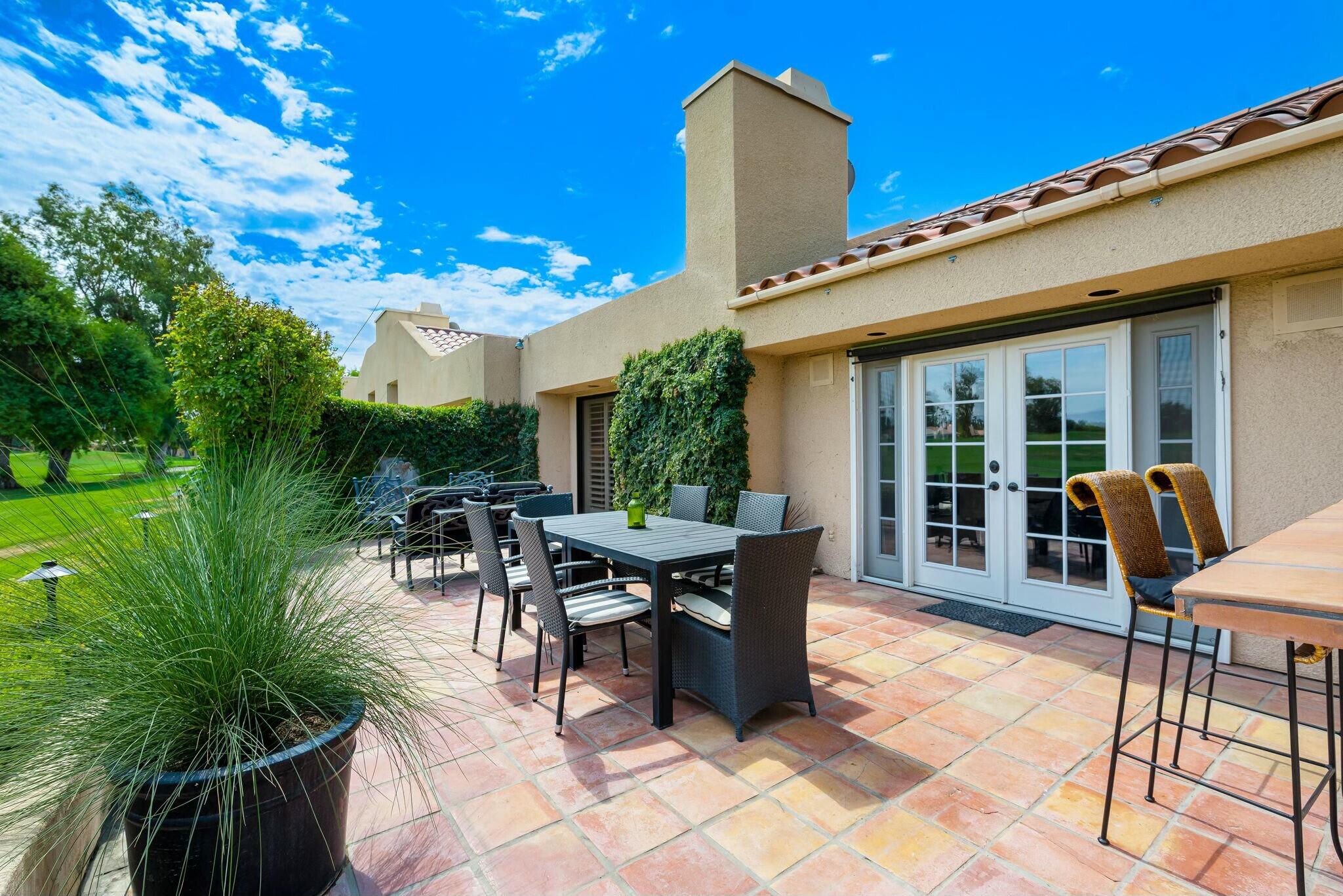 38 Mission Court Rancho Mirage, CA 92270 - Photo 46 of 61 a view of a patio with table and chairs potted plants and a large tree