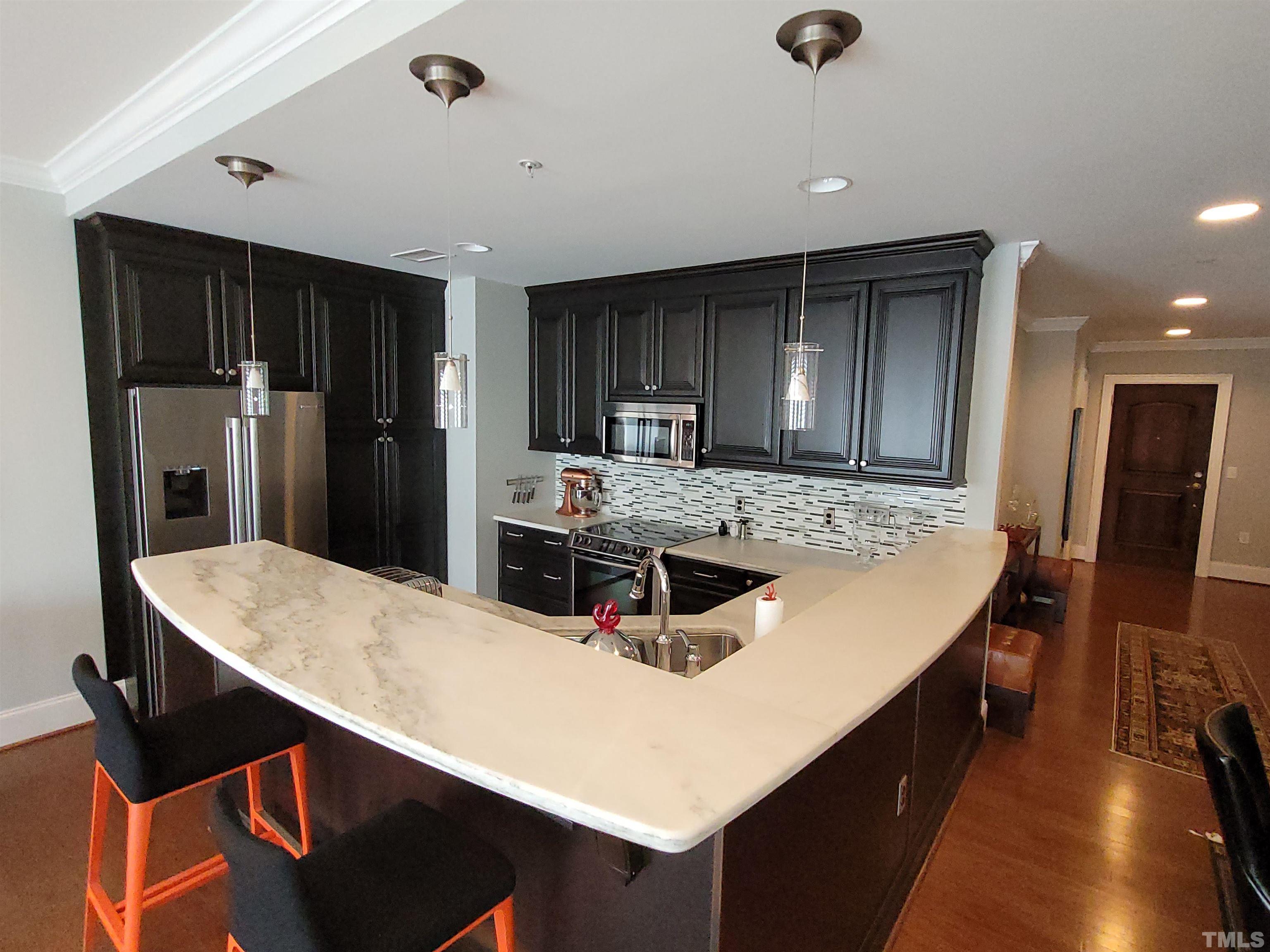 710 Independence Place, Unit 208/2C Raleigh, NC 27603 - Photo 3 of 29 a kitchen with stainless steel appliances granite countertop a sink a stove and refrigerator