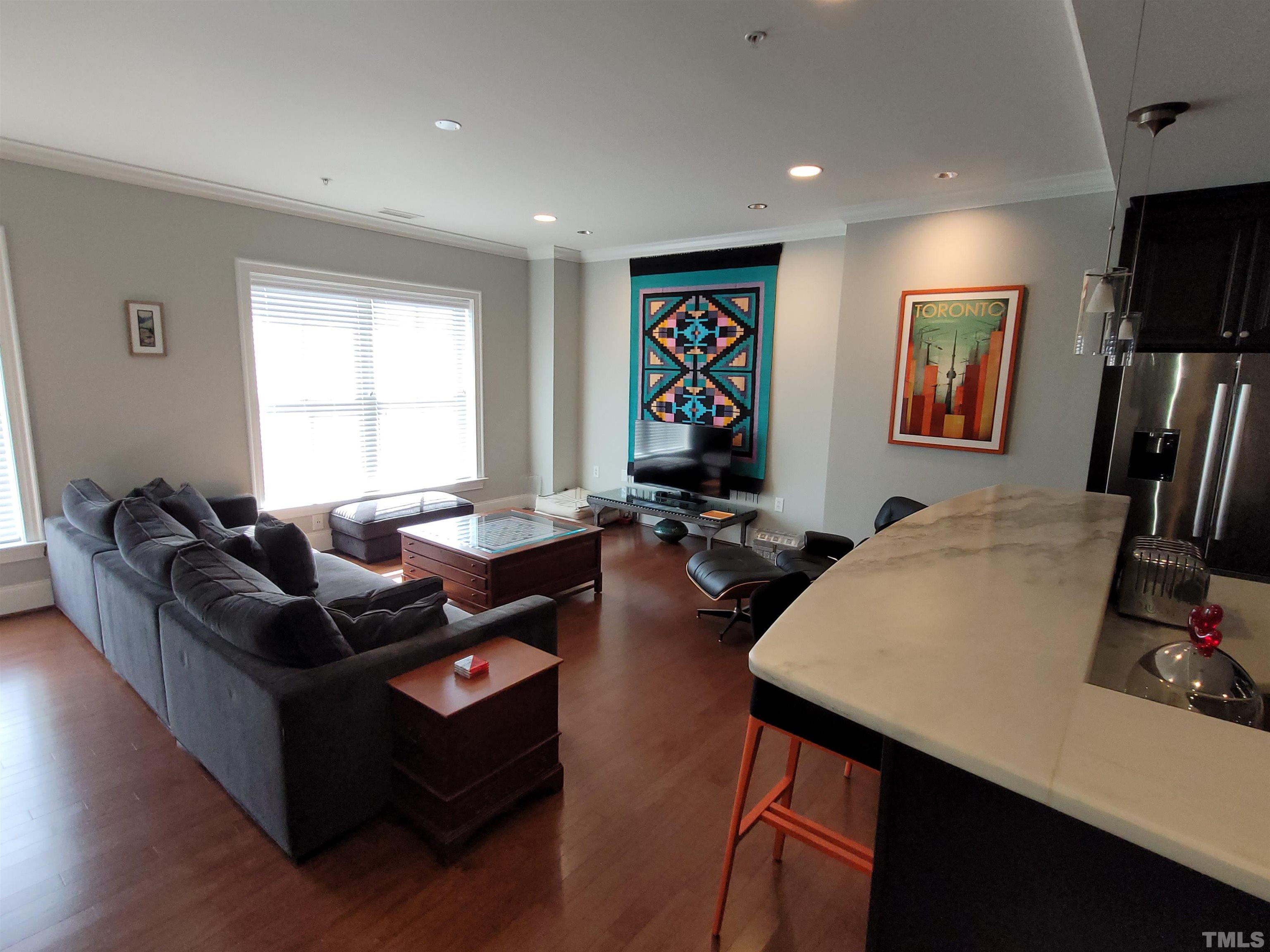 710 Independence Place, Unit 208/2C Raleigh, NC 27603 - Photo 4 of 29 a living room with furniture and a flat screen tv