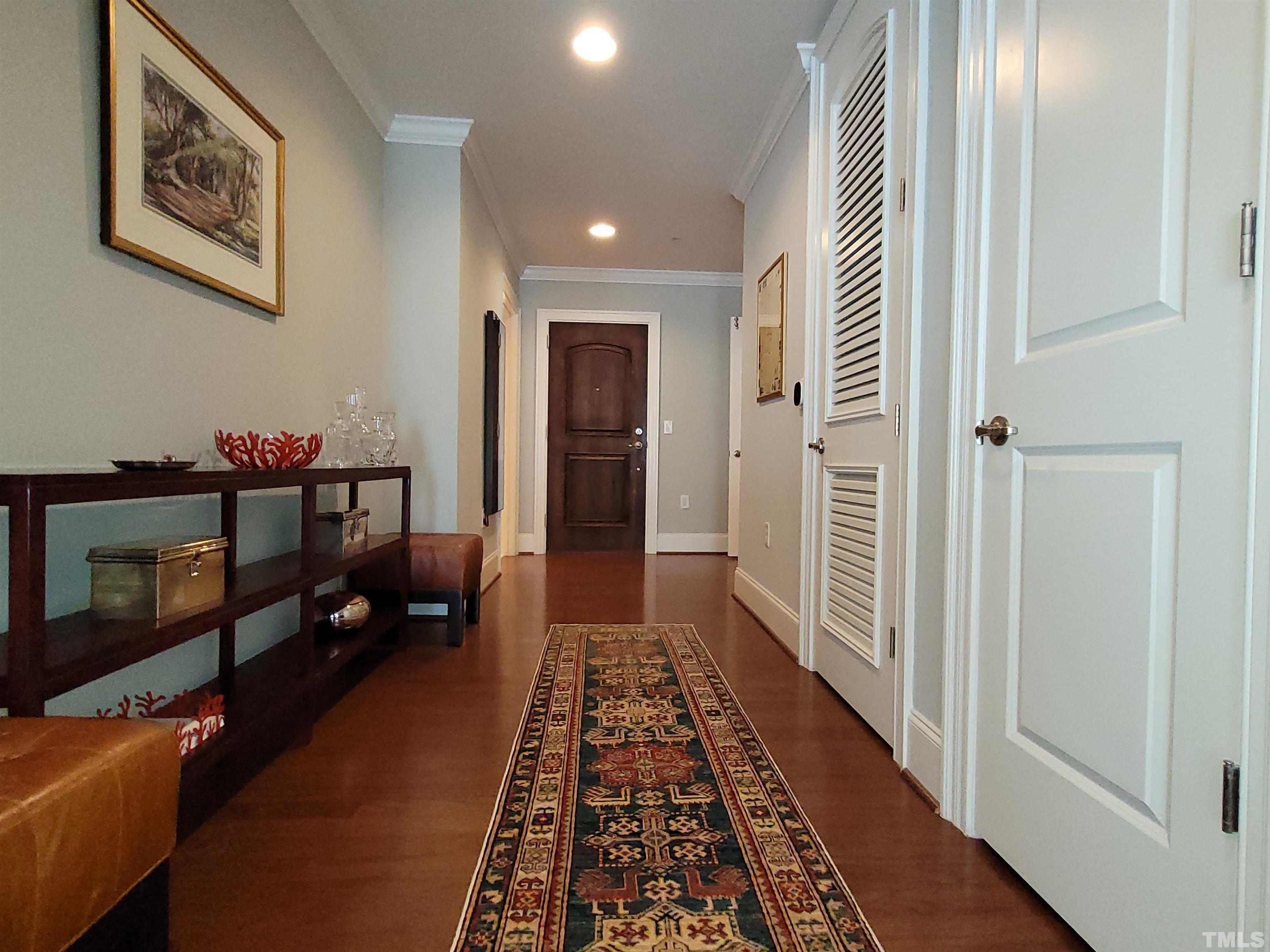 710 Independence Place, Unit 208/2C Raleigh, NC 27603 - Photo 10 of 29 a hallway with painting on the wall and a rug