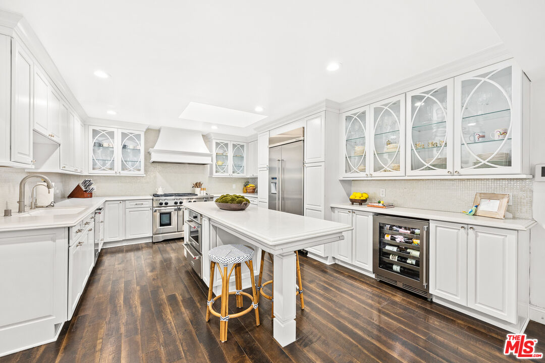 4844 Commonwealth Avenue La Canada Flintridge, CA 91011 - Photo 17 of 43 a open kitchen with stainless steel appliances granite countertop a stove top oven a sink dishwasher and white cabinets with wooden floor