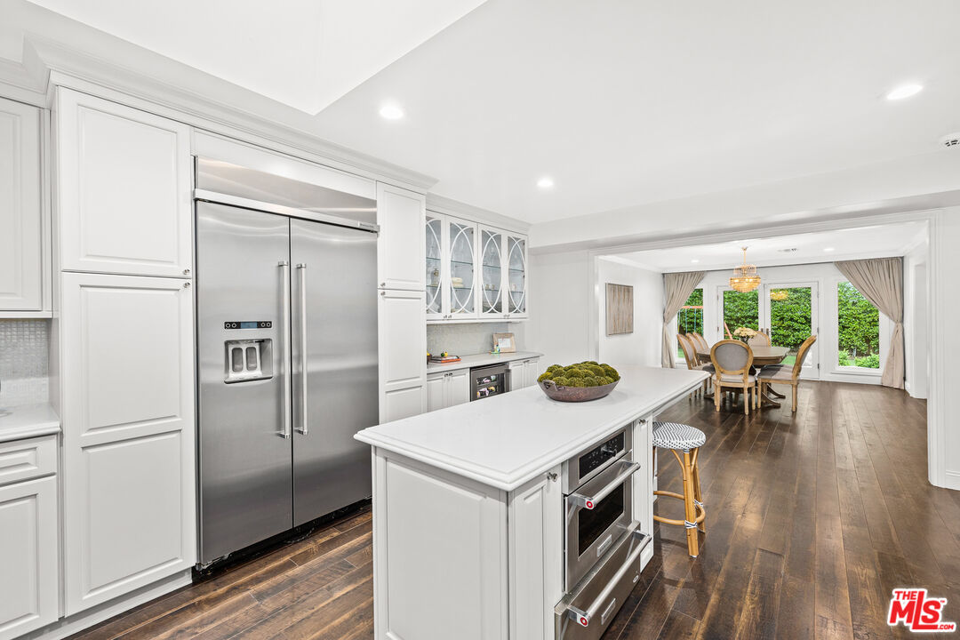 4844 Commonwealth Avenue La Canada Flintridge, CA 91011 - Photo 18 of 43 a kitchen with a refrigerator a stove and a dining table with wooden floor