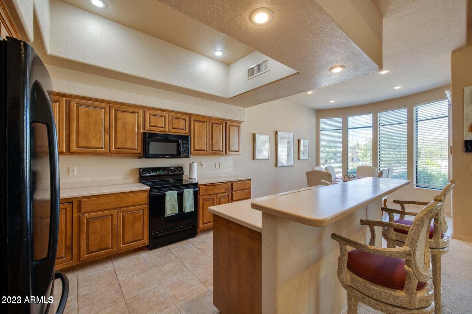 25603 North Sago Drive Rio Verde, AZ 85263 - Photo 2 of 25 a large kitchen with stainless steel appliances granite countertop a stove top oven a sink dishwasher a dining table and chairs with wooden floor