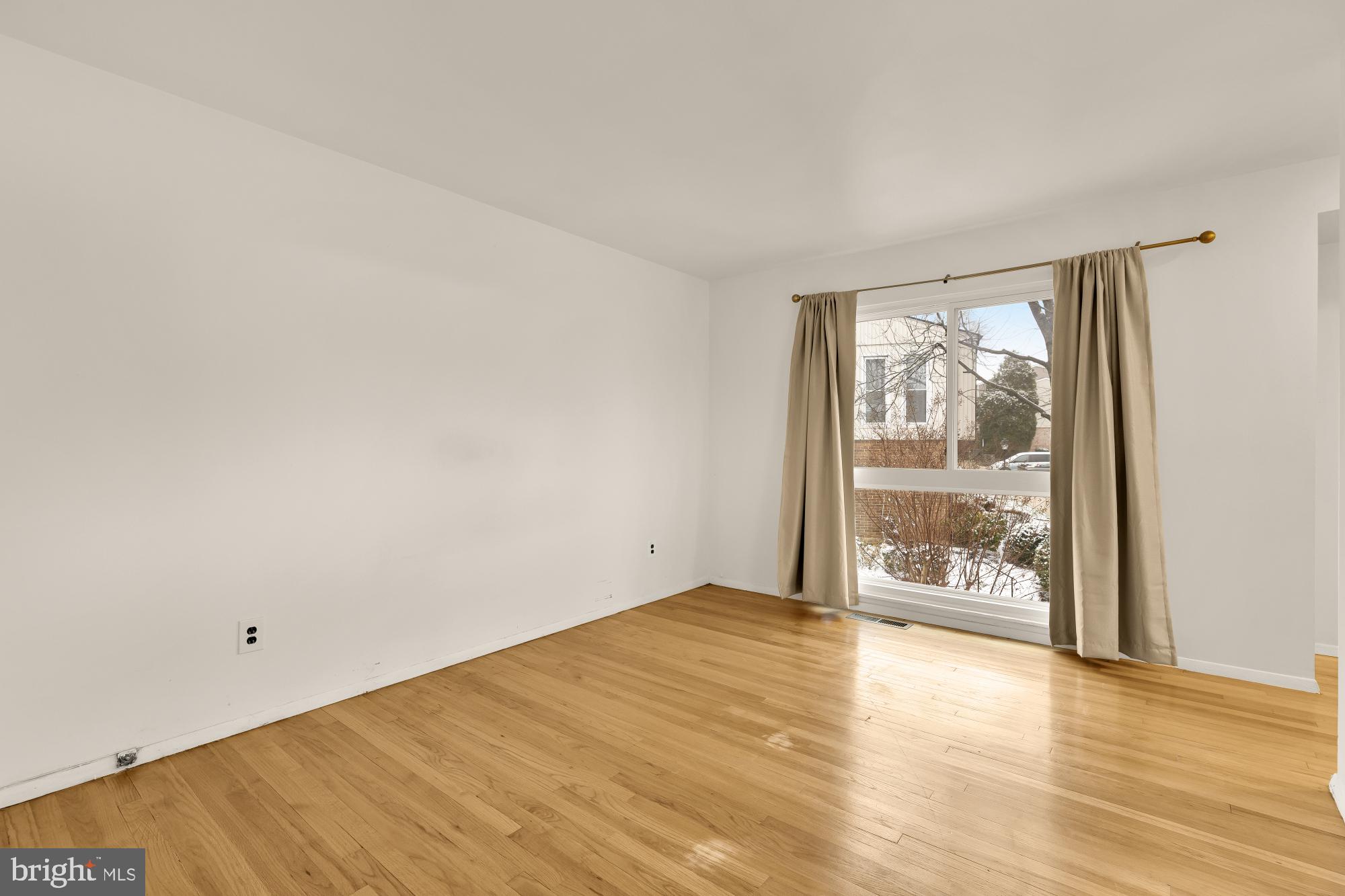 7149 Mill Run Drive, Unit 155 Rockville, MD 20855 - Photo 13 of 22 a view of an empty room with wooden floor and a window