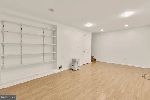 a room with wooden floor and cabinets
