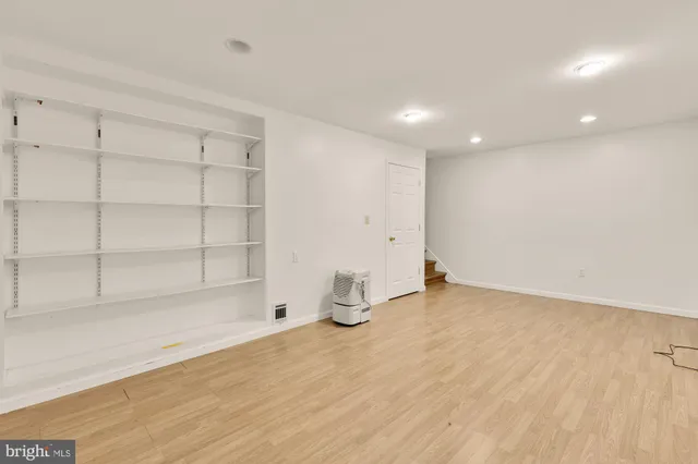 a room with wooden floor and cabinets