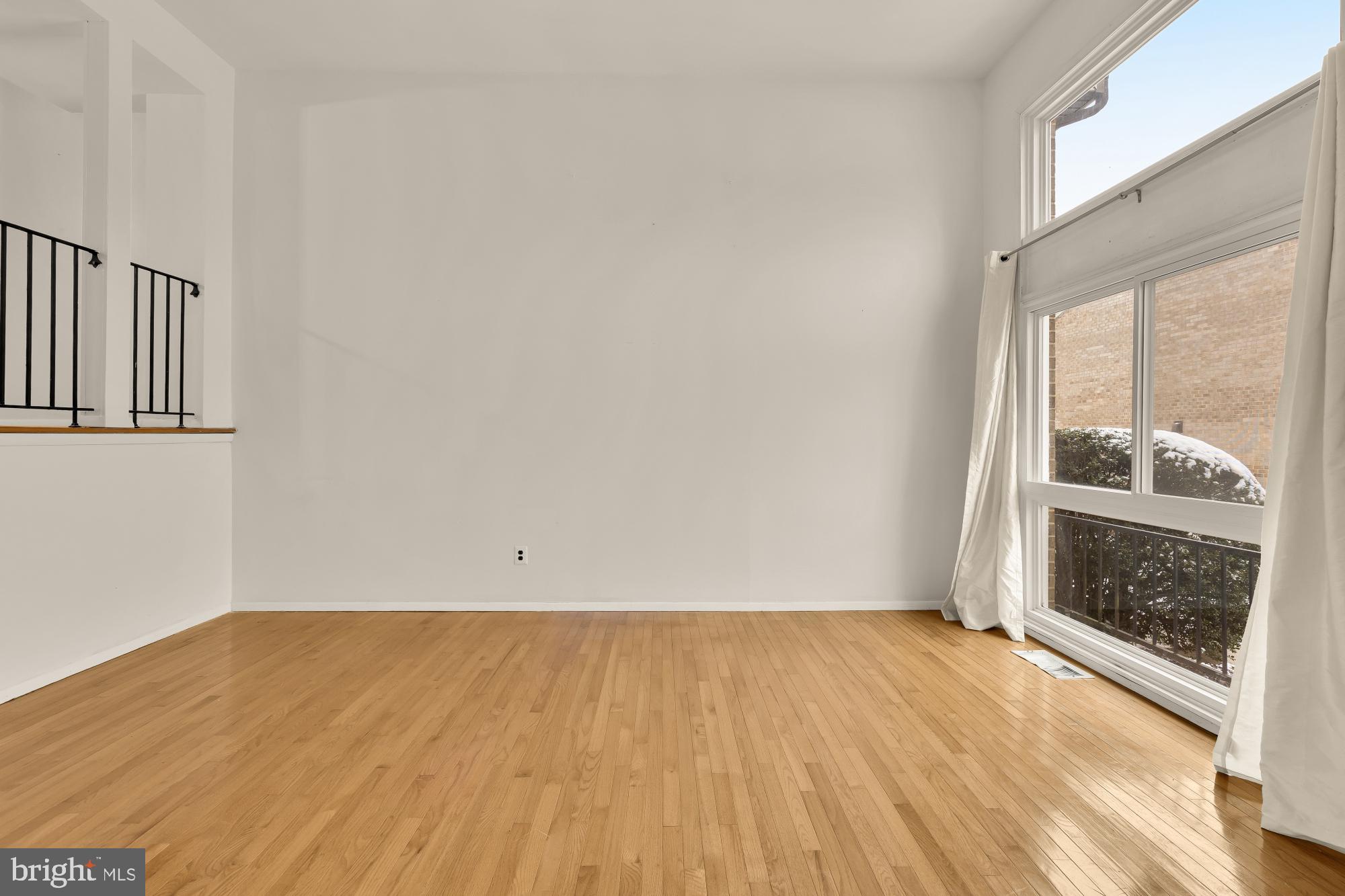 7149 Mill Run Drive, Unit 155 Rockville, MD 20855 - Photo 4 of 22 an empty room with wooden floor and windows