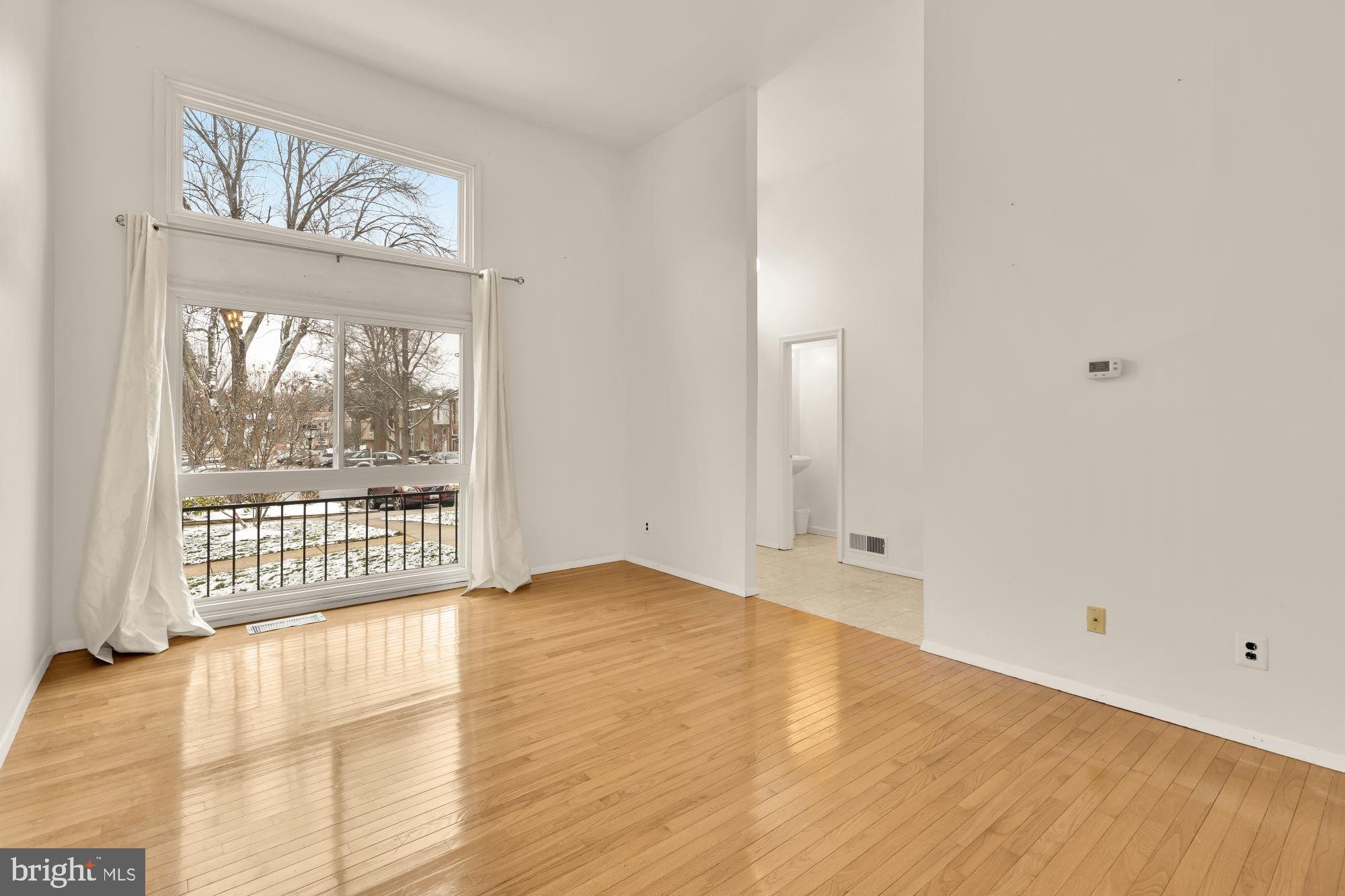 7149 Mill Run Drive, Unit 155 Rockville, MD 20855 - Photo 6 of 22 a view of an empty room with wooden floor and a window