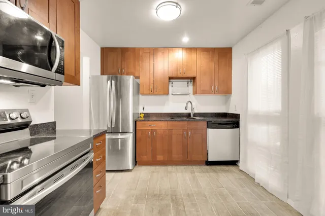 a kitchen with stainless steel appliances a refrigerator stove and microwave