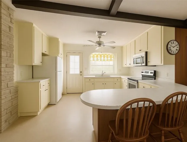 a large kitchen with kitchen island a stove a sink a dining table and chairs