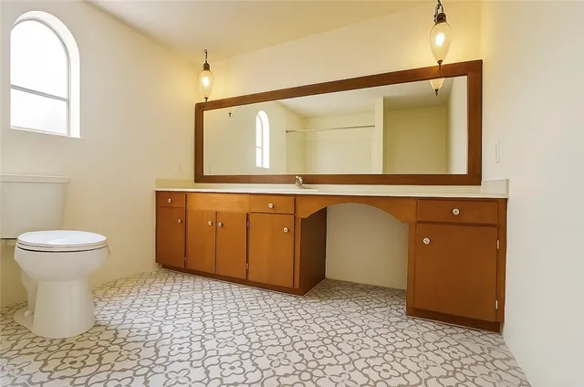 a bathroom with a sink a toilet and mirror