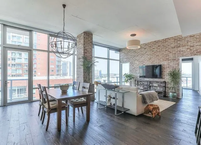 a living room with furniture fireplace and a large window