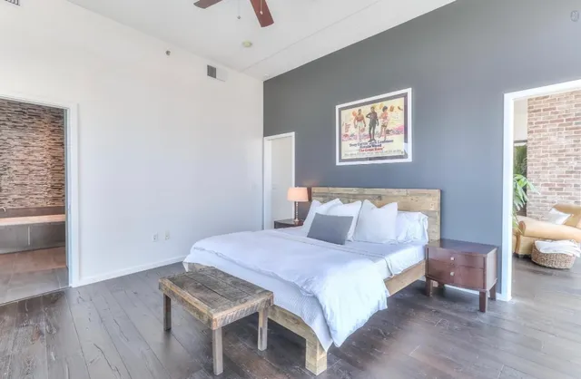 a bedroom with a bed and a table with wooden floor