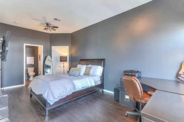 a bedroom with a bed chair and dresser