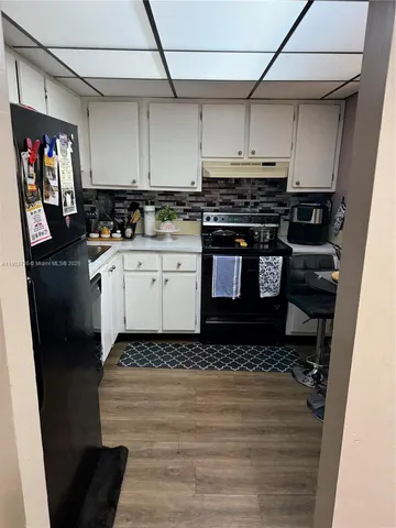 a kitchen with a stove and white cabinets