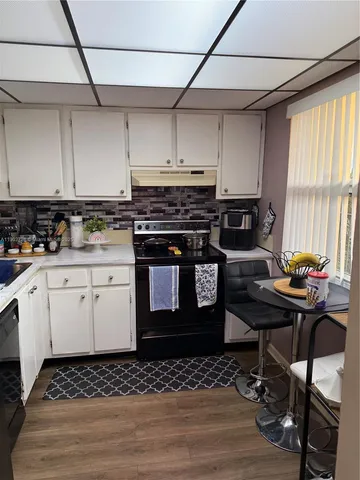 a kitchen with a cabinets and stove top oven