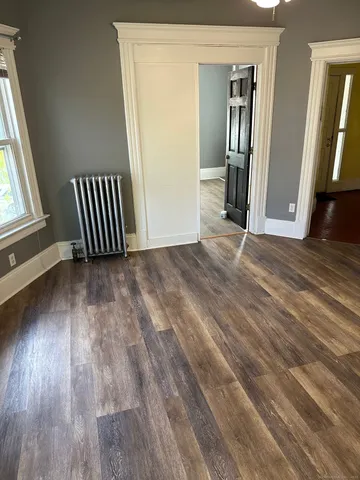 an empty room with wooden floor and stairs