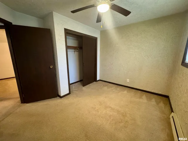 an empty room with a chandelier fan
