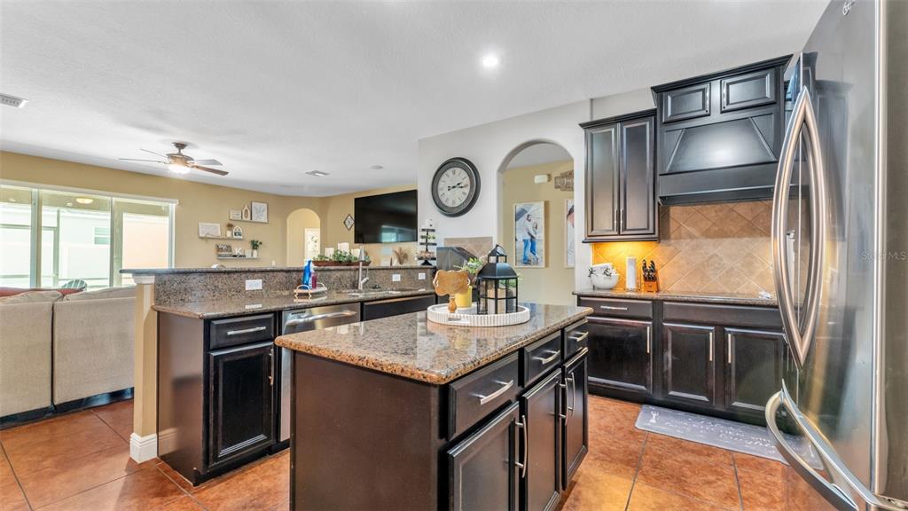 4105 Berkshire Loop Lakeland, FL 33813 - Photo 18 of 41 a kitchen with kitchen island granite countertop a sink stove and refrigerator