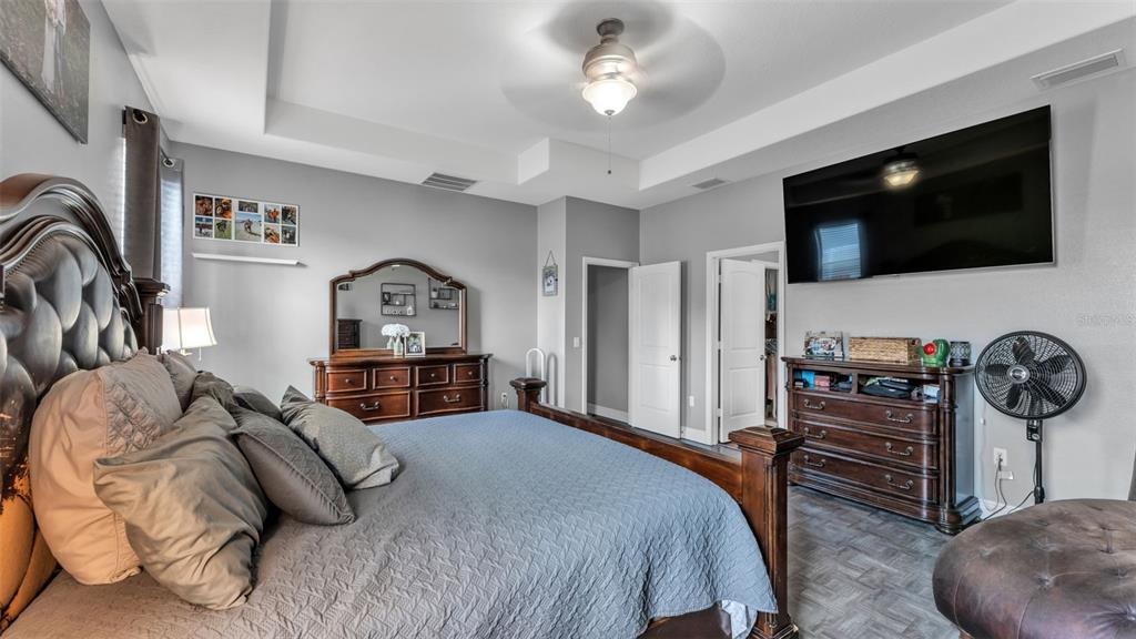 4105 Berkshire Loop Lakeland, FL 33813 - Photo 23 of 41 a bedroom with a bed a flat screen tv and a couch