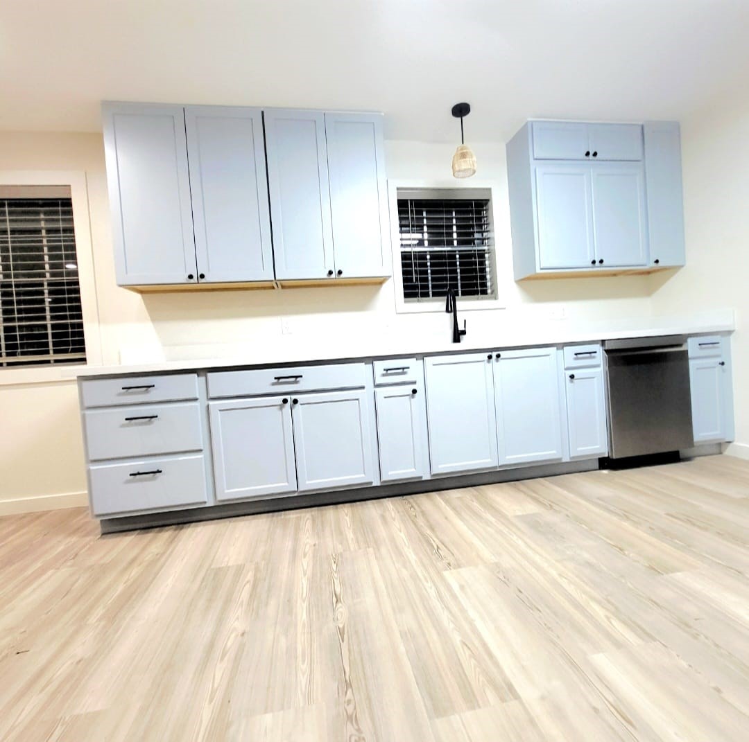 1608 Longhofer Street Brenham, TX 77833 - Photo 15 of 24 a kitchen with granite countertop a stove a sink and a microwave