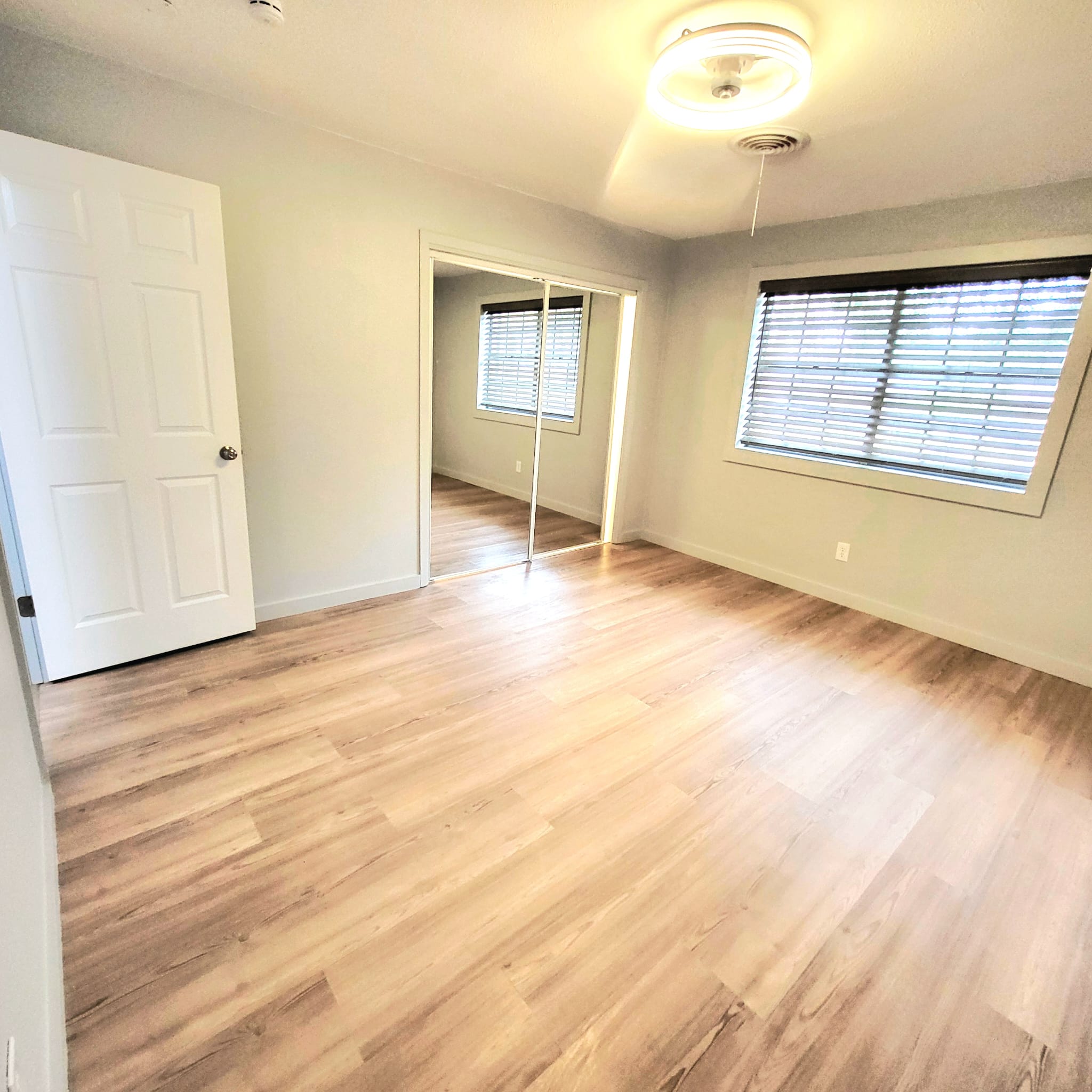 1608 Longhofer Street Brenham, TX 77833 - Photo 18 of 24 an empty room with wooden floor kitchen view and windows