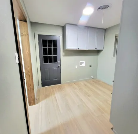 an empty room with a window and wooden floor