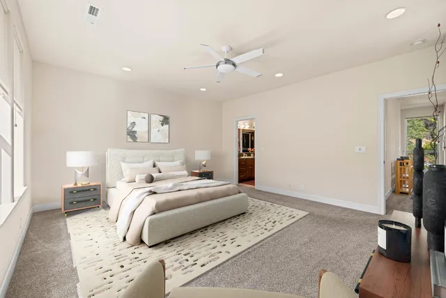 a bedroom with a large bed and a chandelier