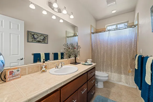 a kitchen with stainless steel appliances granite countertop a stove and a view of living room