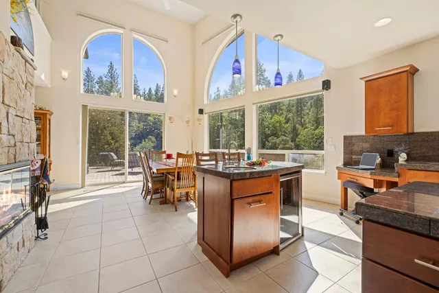 a kitchen with stainless steel appliances kitchen island granite countertop a table chairs and a refrigerator