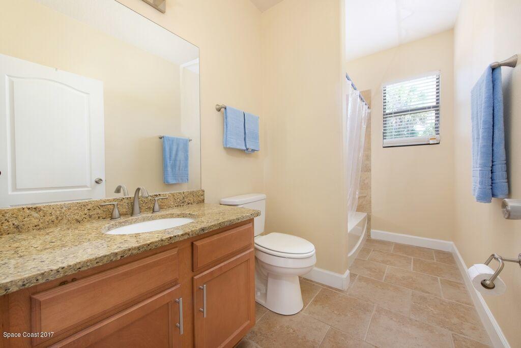 249 Franzing Street Palm Bay, FL 32908 - Photo 15 of 20 a bathroom with a granite countertop sink toilet and mirror