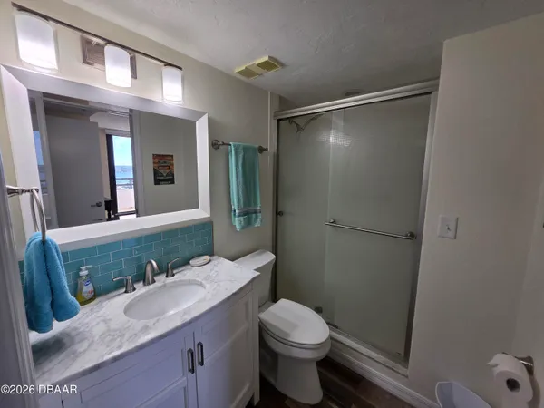 a bathroom with a granite countertop sink toilet and shower