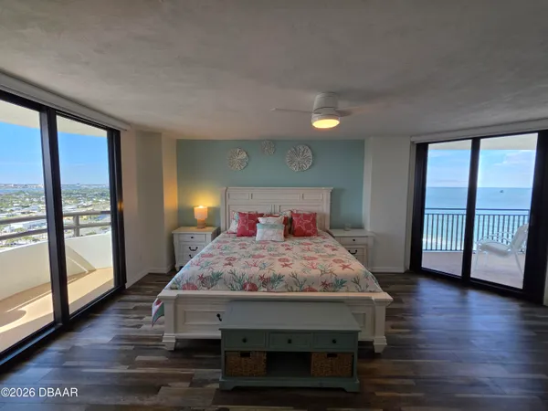 a bedroom with a bed and large windows