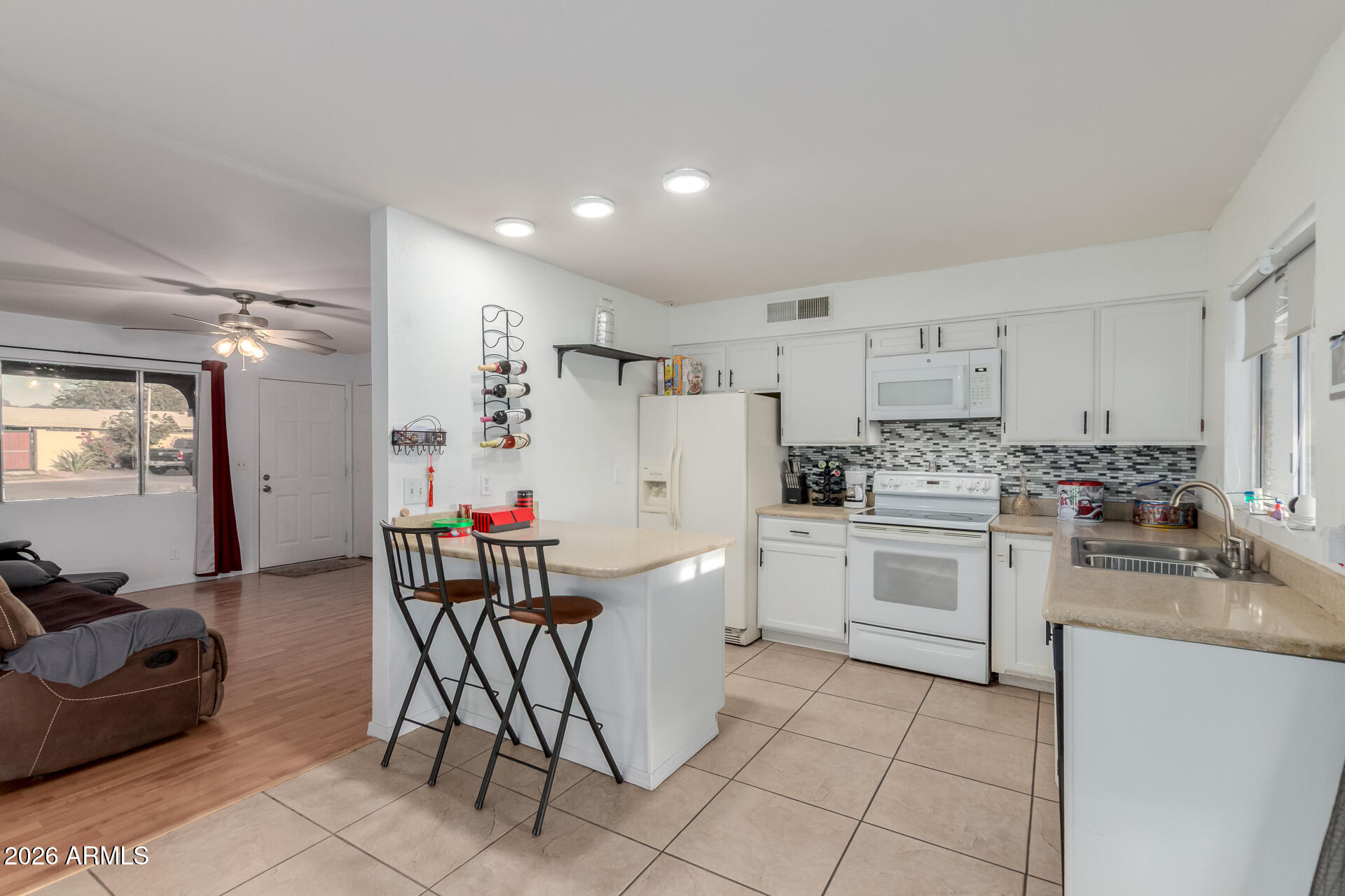 9403 East Cisco Road Mesa, AZ 85207 - Photo 10 of 20 a kitchen with a refrigerator and white cabinets