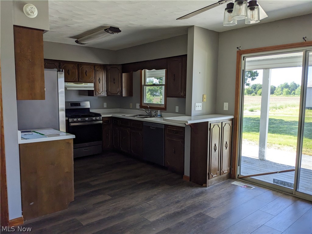 13096 Smith Road Wellington, OH 44090 - Photo 8 of 24 Kitchen with wood-finish flooring, dark wood cabinetry, and white countertops