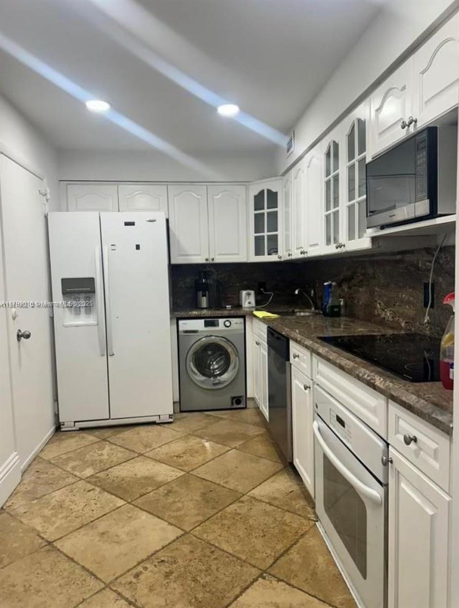 6770 Indian Creek Drive, Unit TSB Miami Beach, FL 33141 - Photo 4 of 12 a kitchen with a stove top oven sink and cabinets
