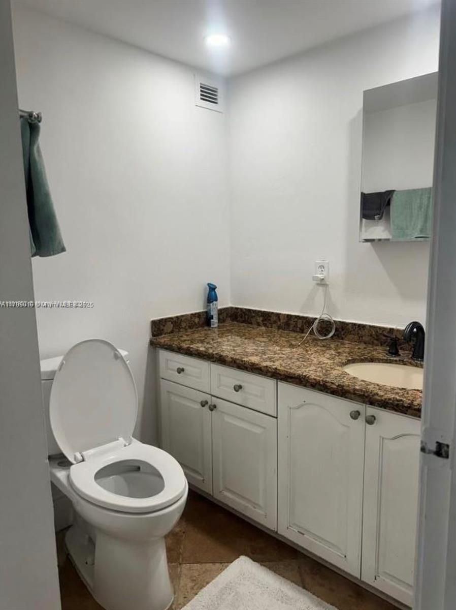 6770 Indian Creek Drive, Unit TSB Miami Beach, FL 33141 - Photo 9 of 12 a bathroom with a granite countertop toilet sink and mirror