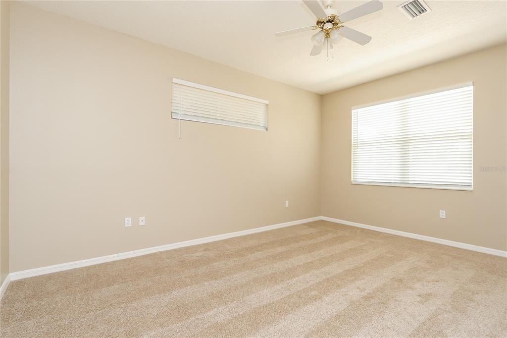 6239 Blue Runner Court Lakewood Ranch, FL 34202 - Photo 13 of 15 an empty room with a chandelier fan and windows