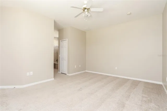 an empty room with a ceiling fan and a window