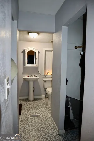 a bathroom with a toilet sink and mirror