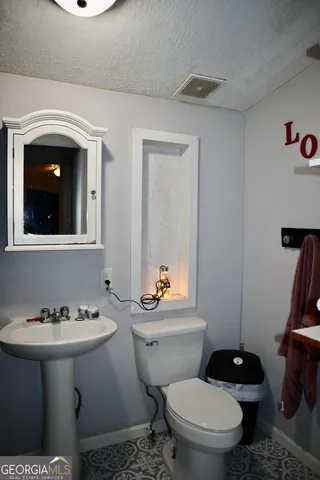a bathroom with a sink toilet and a mirror
