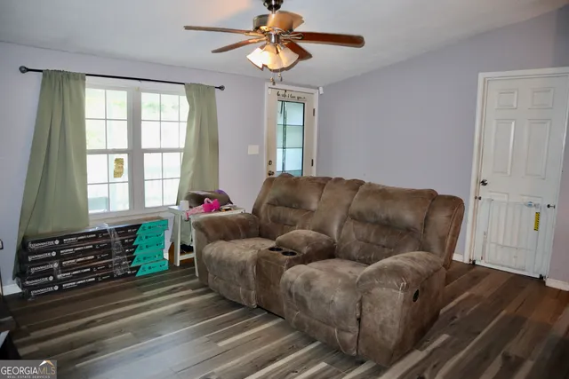 a living room with couches cabinet and a fireplace