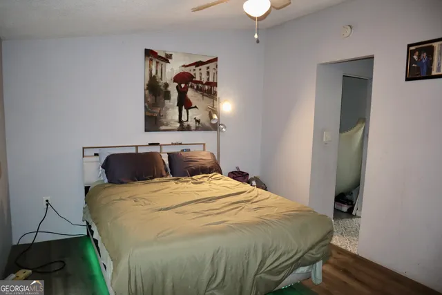 a bedroom with a bed and a painting on the wall