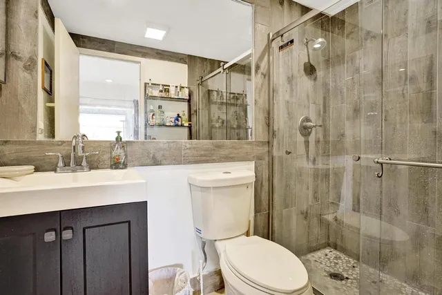 a bathroom with a sink a toilet and shower