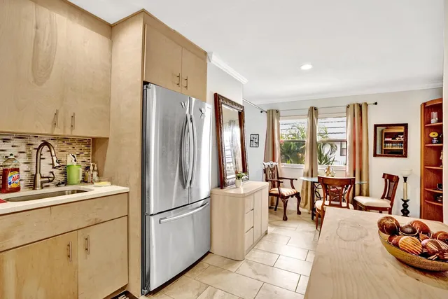 a kitchen with stainless steel appliances a refrigerator a sink a stove and white cabinets next to a window