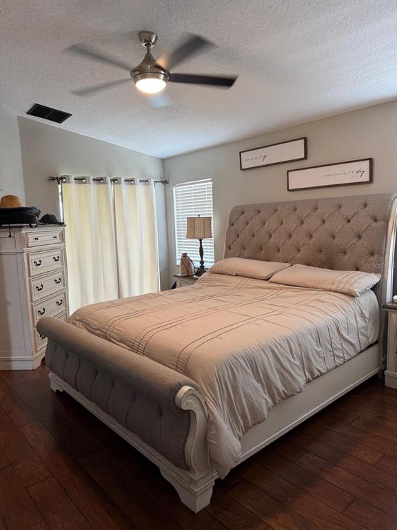 41430 Roger Giles Road Umatilla, FL 32784 - Photo 11 of 27 a bedroom with a large bed and a ceiling fan