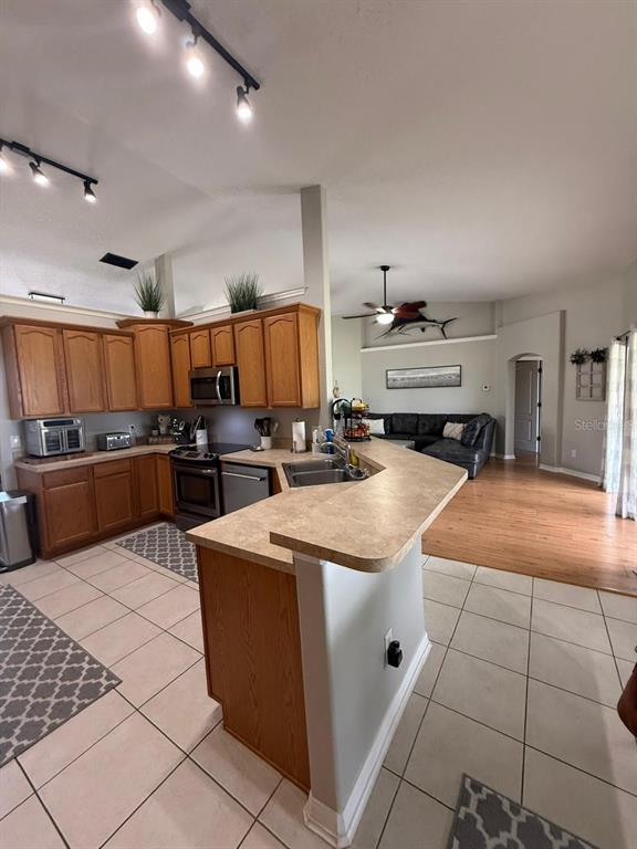 41430 Roger Giles Road Umatilla, FL 32784 - Photo 16 of 27 a kitchen with stainless steel appliances granite countertop a sink counter space cabinets and a view of living room