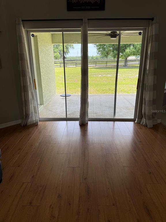 41430 Roger Giles Road Umatilla, FL 32784 - Photo 23 of 27 a view of an empty room with wooden floor and a window