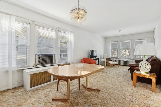 a living room with furniture a fireplace and a chandelier