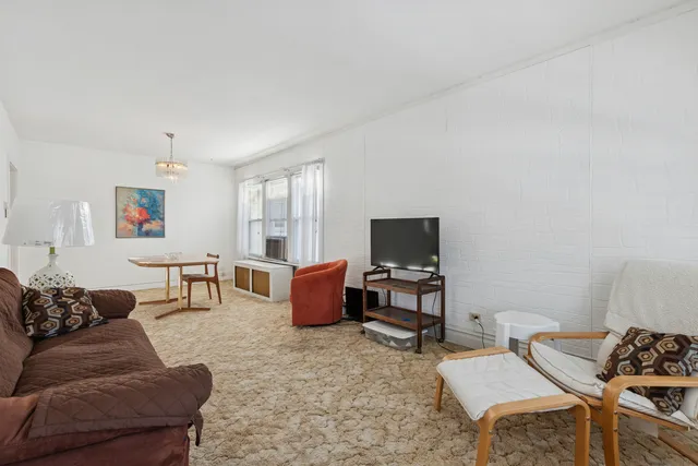 a living room with furniture a flat screen tv and a window